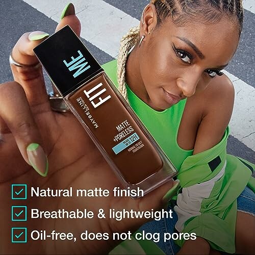 Woman holding Maybelline Fit Me Matte Foundation with benefits listed.