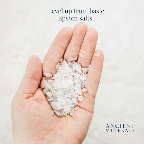 Hand holding Epsom salts with text 'Level up from basic Epsom salts.'