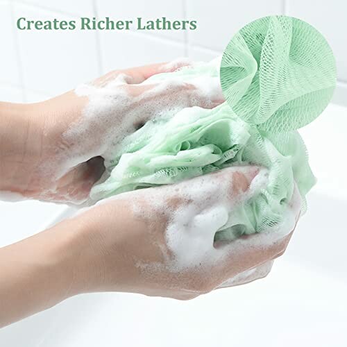 Hands washing with green loofah and soap lather.