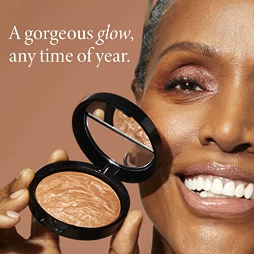 Smiling person with makeup powder compact and text 'A gorgeous glow, any time of year.'