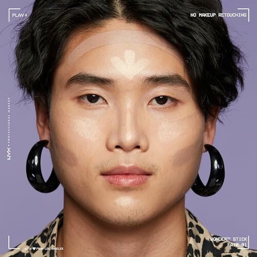 Man with contour makeup and large earrings.