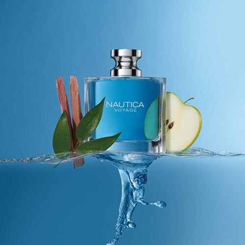 Voyage perfume bottle with apple and leaves on blue background