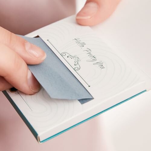 Person opening a decorative envelope with blue paper.