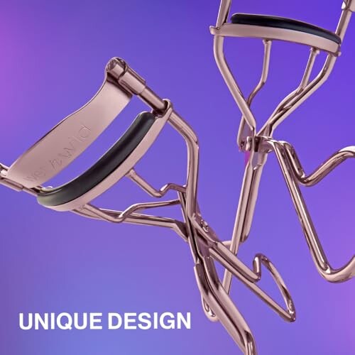 Rose gold eyelash curlers on purple background.