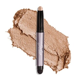 Shimmer eyeshadow stick with smudged gold texture.