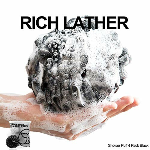 Hand holding a black shower puff with rich lather