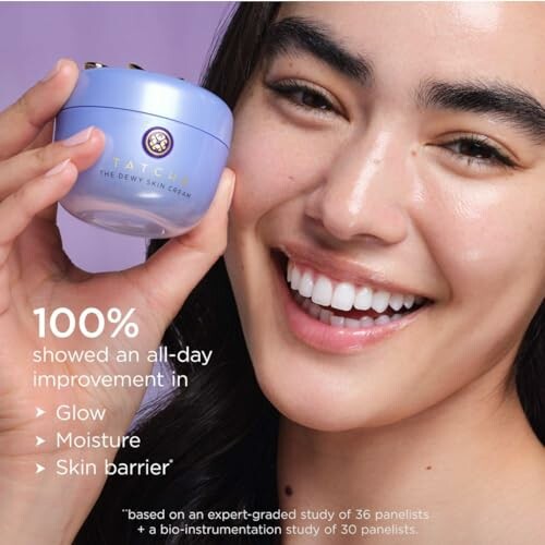 Smiling person holding Tatcha Dewy Skin Cream.