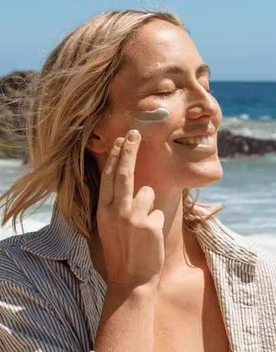 Woman applying sunscreen at the beach